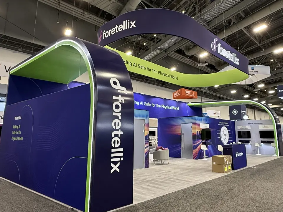 Green-topped arch corner of the booth with logo lettering