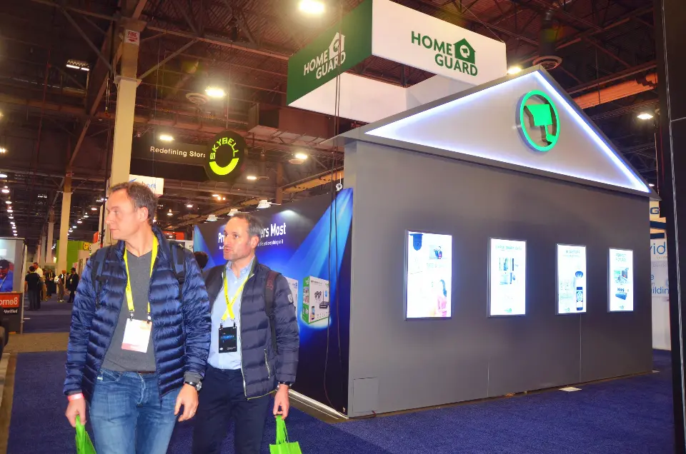 Side of the house-shaped booth with a lit roofline and framed displays