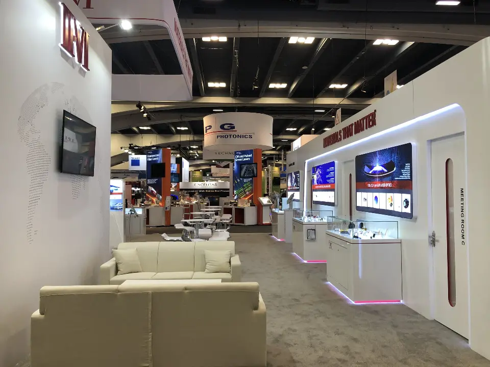 Lounge area with cream sofas between white walls and backlit product displays