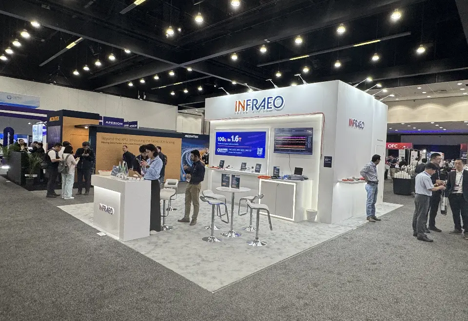 Infraeo stand at OFC seen from the opposite corner with visitors at the logo counter and high tables