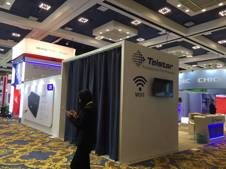 Corner of a curtained room with a visitor walking past the Telstar wall