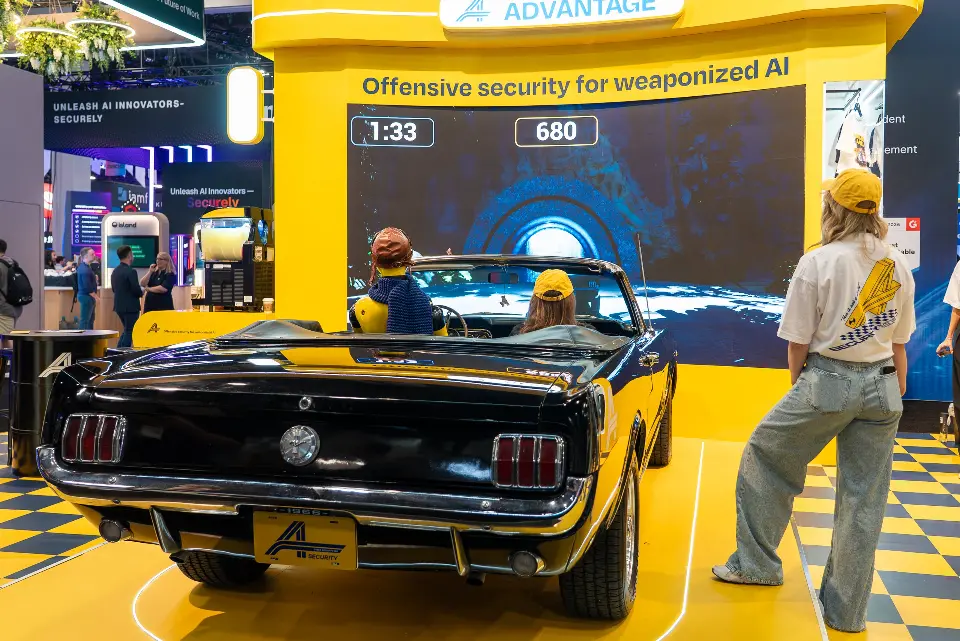 Rear of the convertible with a guest in a yellow cap watching the driving game timer and score