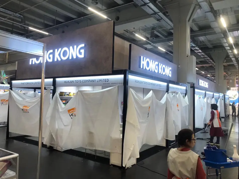 Long run of fascia with repeated HONG KONG lettering over a line of covered stands