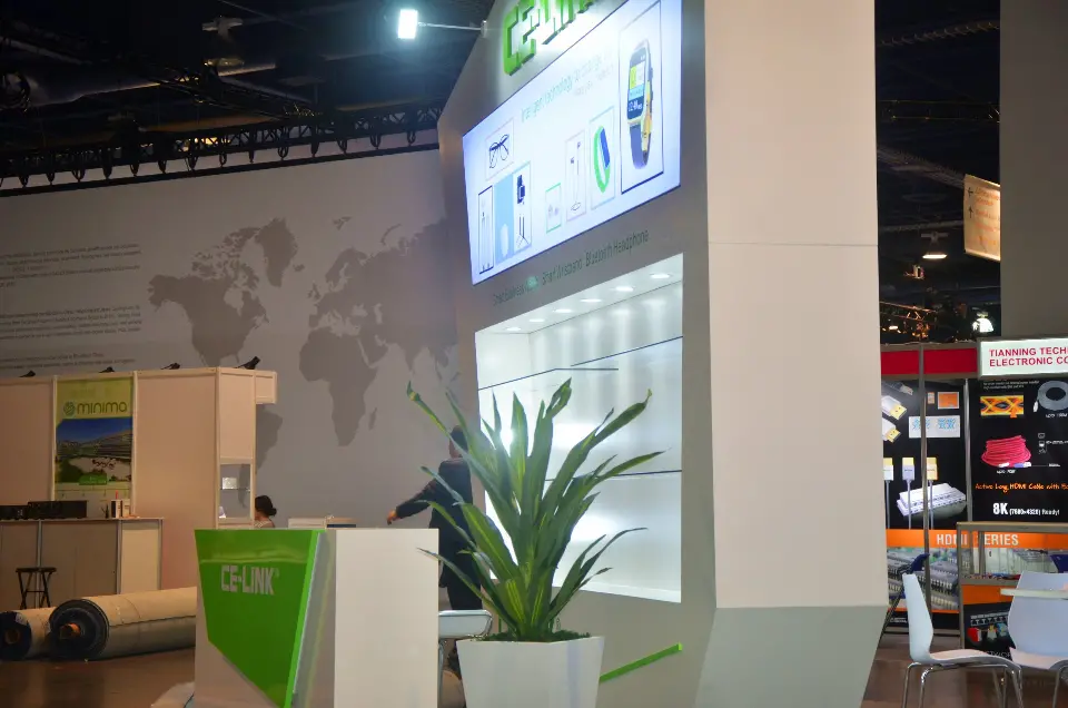 Tall wall with lit shelves, potted plant and green counter