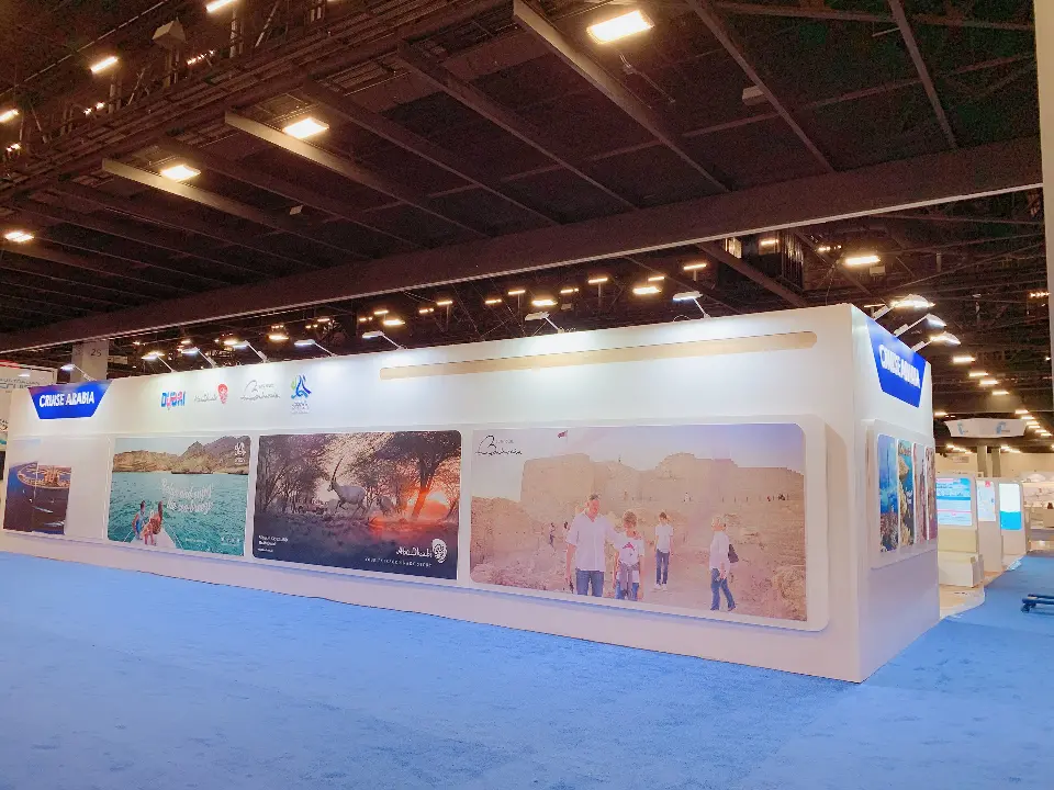 Long graphic wall of beach and city photos along the booth exterior