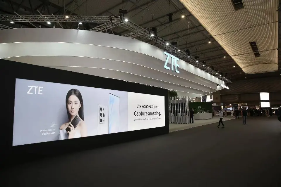 Long dark wall with a large backlit phone graphic and ZTE logo