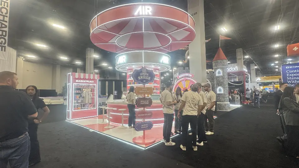 AIR booth with staff in white shirts beside the striped canopy