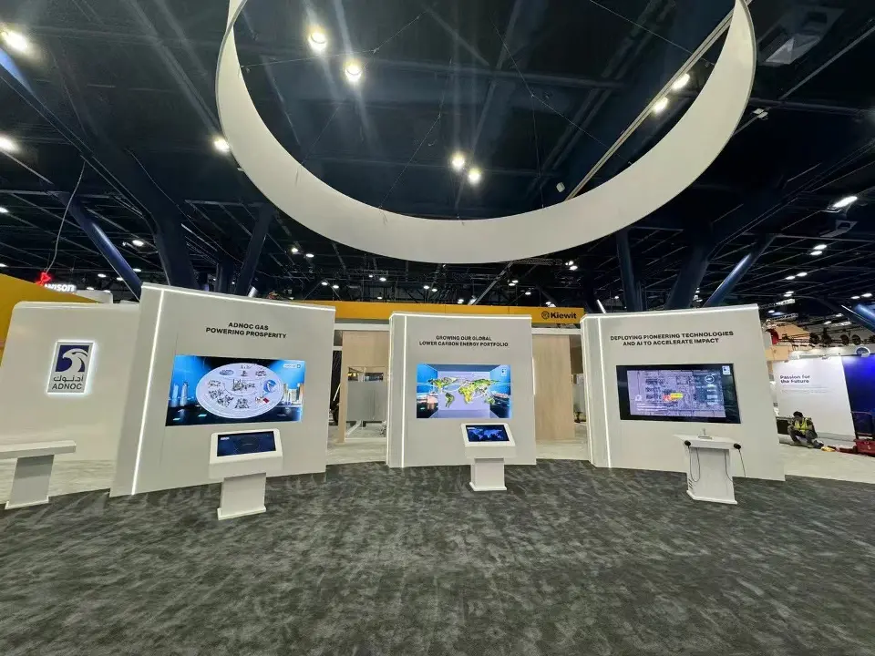 Display walls with screens and kiosks seen beneath the white ring