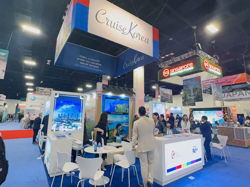 Cruise Korea island under hanging banner with Incheon lightbox, lit counter and busy meeting tables