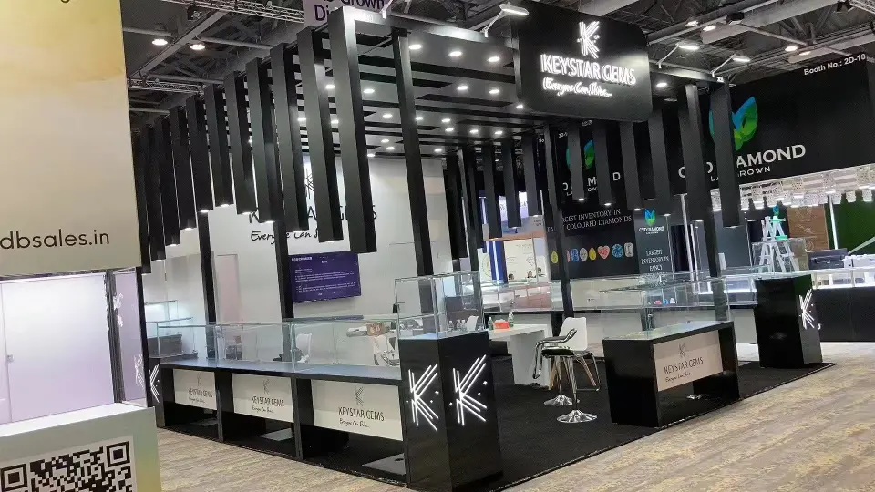 Side aisle view of black-framed showcases and the Keystar Gems logo panels