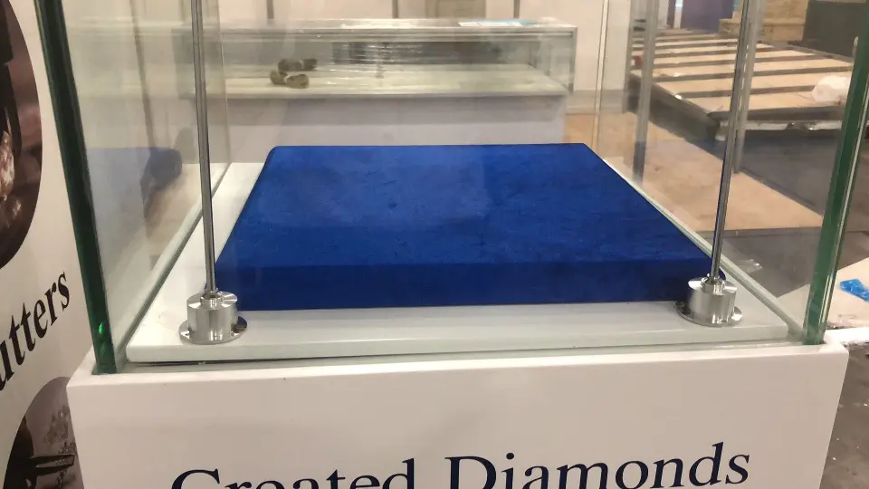 Glass case and blue tray above bold Created Diamonds lettering on the base