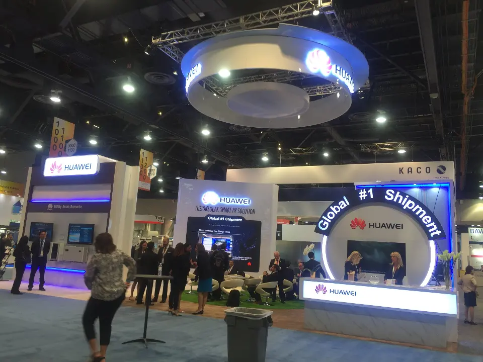 Visitors walking past the finished booth under the lit ring on show day