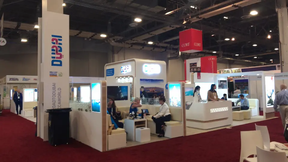 Visitors seated in cream lounge nooks on red carpet