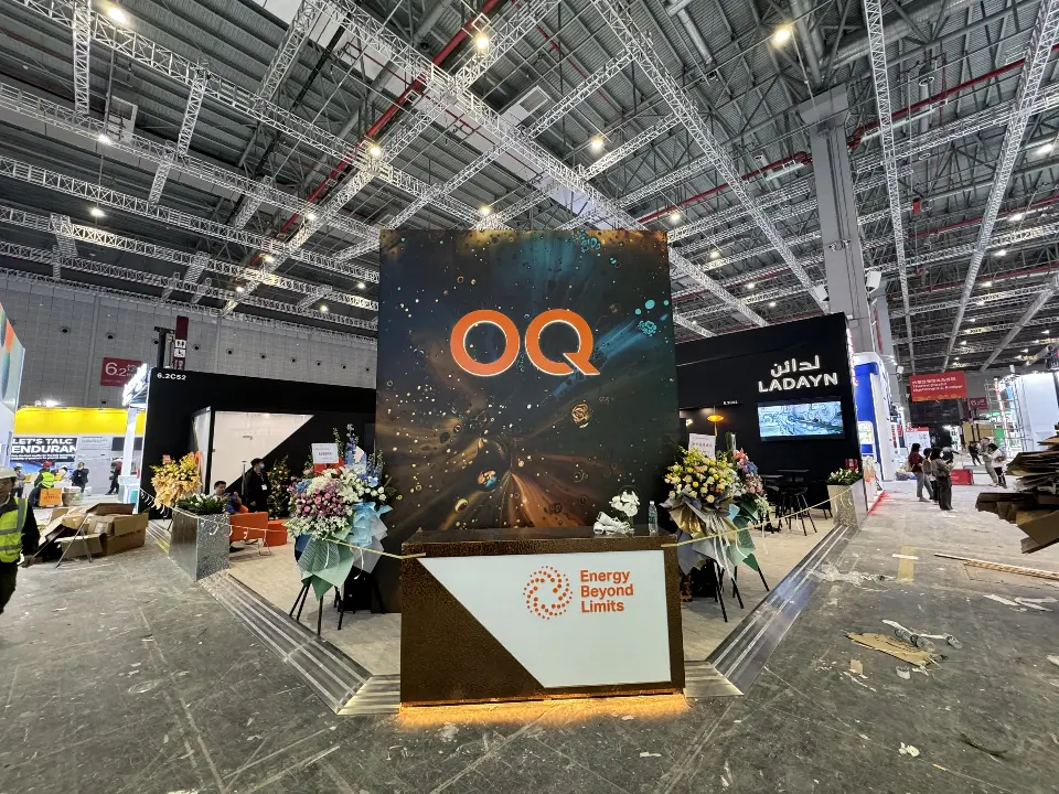 Wide front view of the booth with the OQ tower, flowers and rear video screen