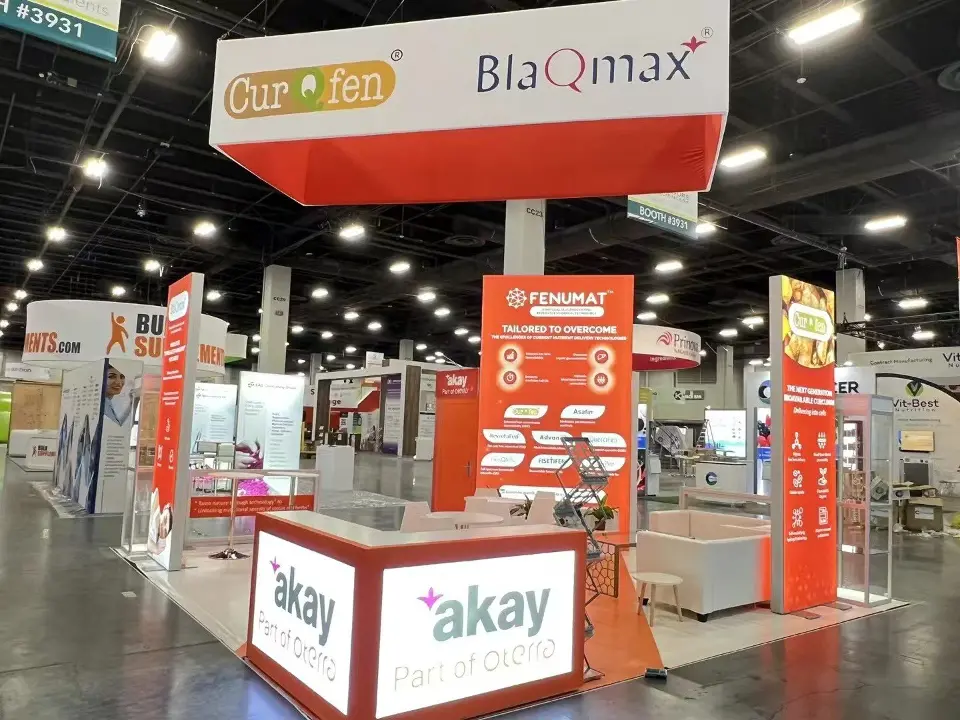 Akay booth front with lit counter, CurQfen and BlaQmax headers and red towers