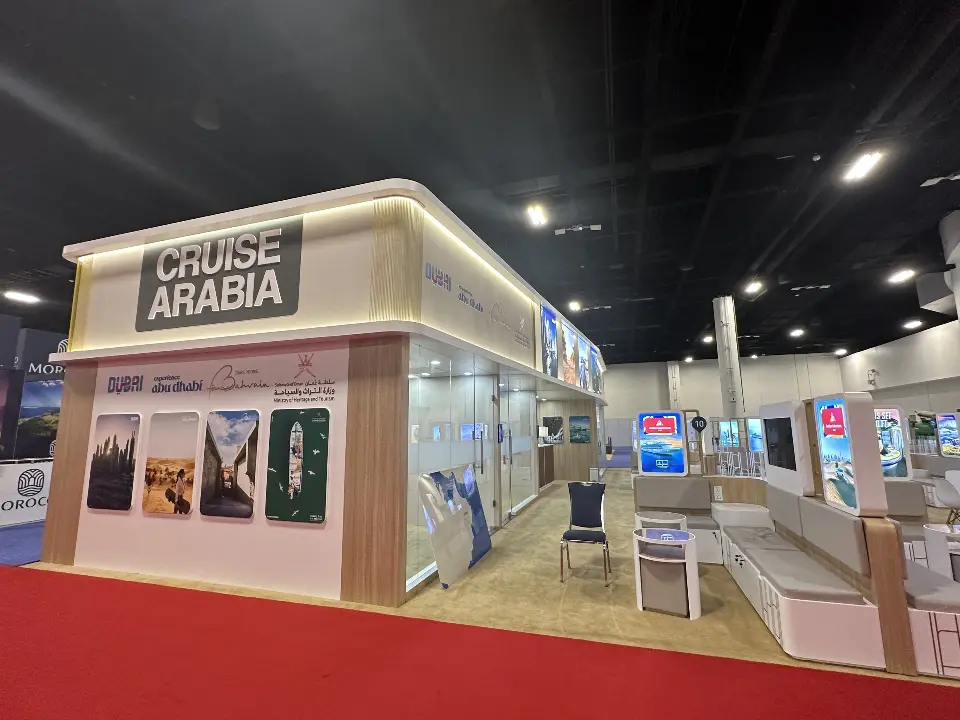 Cruise Arabia corner with travel photo panels and lit header over red carpet
