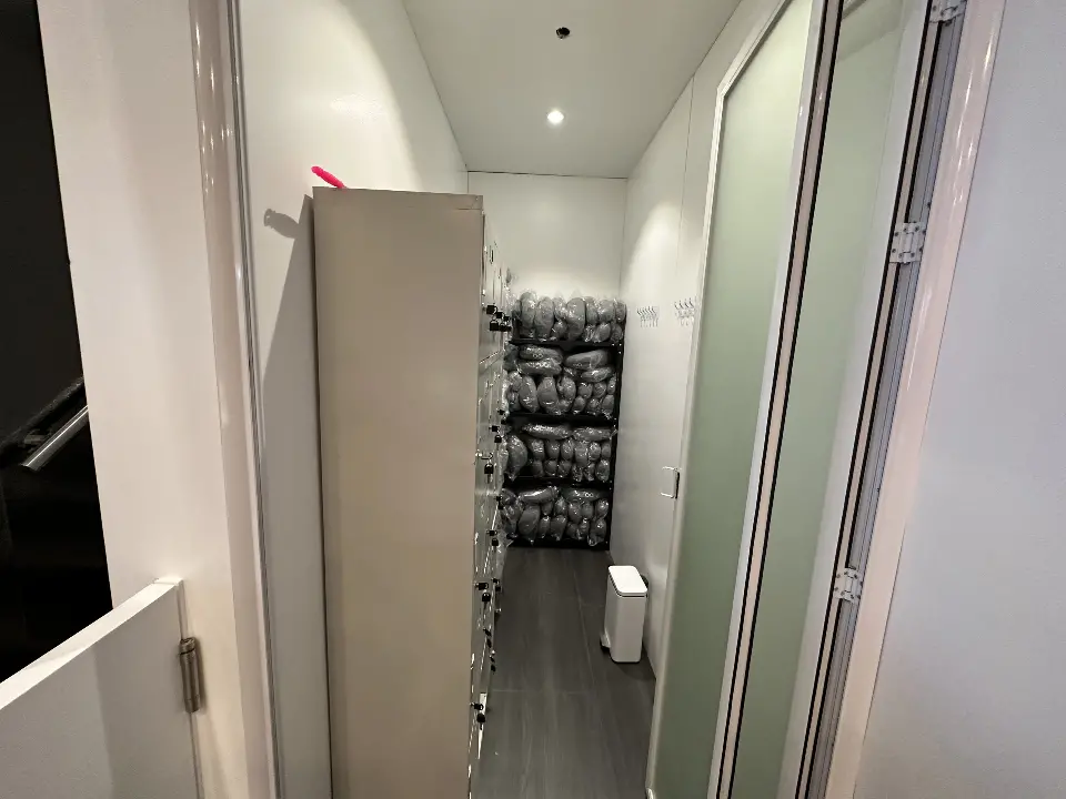 Narrow corridor with white walls leading to a back room