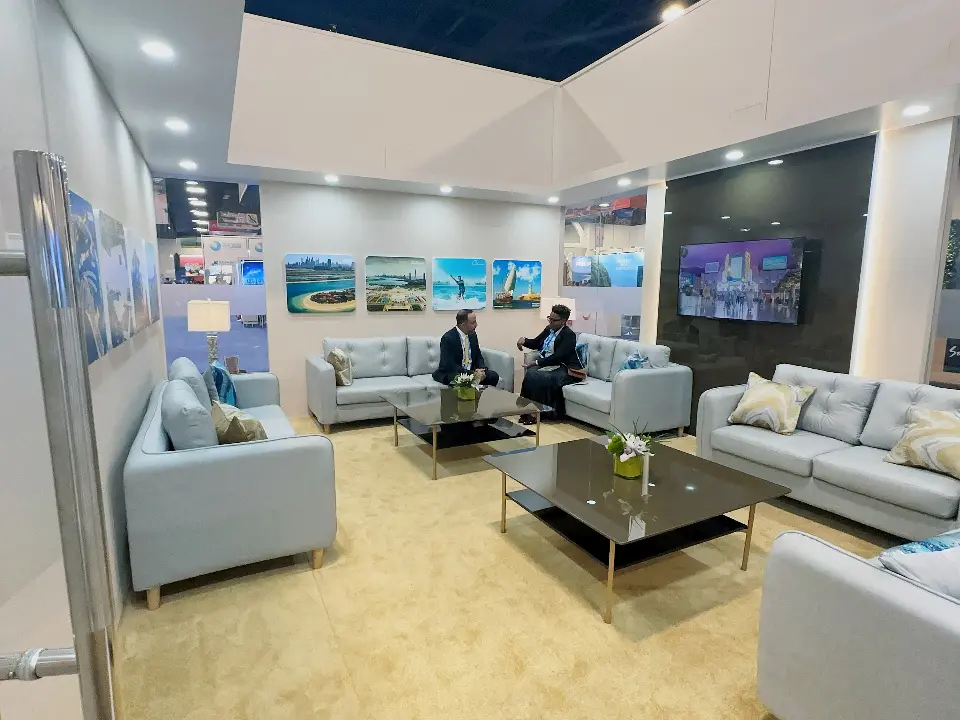 Inside the Cruise Arabia private lounge with pale blue sofas, coffee tables, destination photos and wall screen