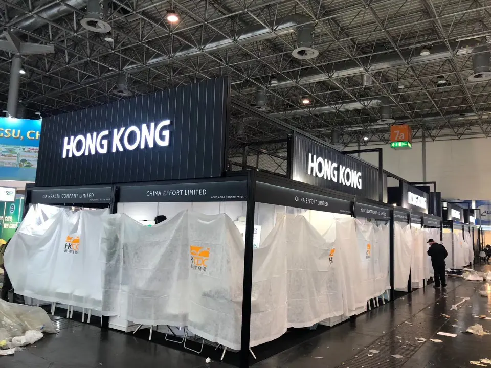 Aisle view of the black pavilion fascia with white dust covers on every stand