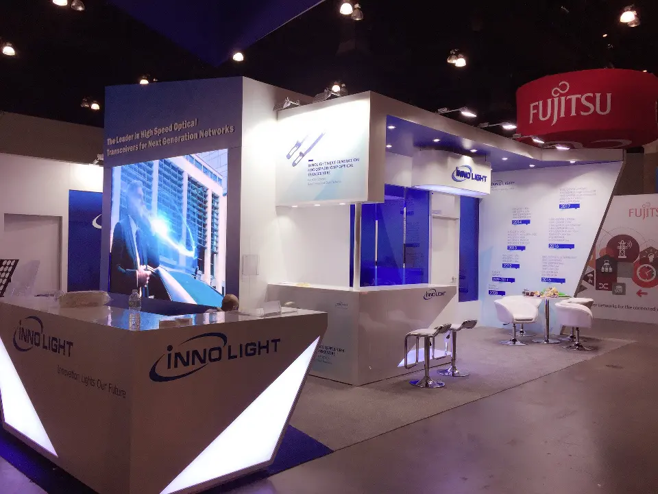 Angled reception counter with a lit white triangle and InnoLight logo