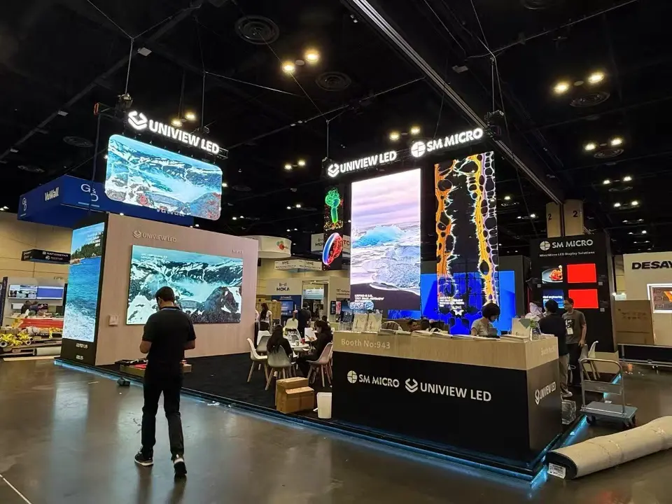 Visitor standing before the video screen wall and branded counter