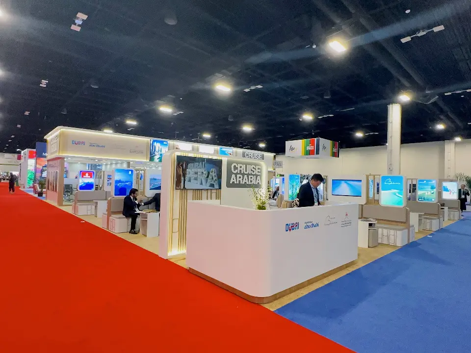 Reception counter with Dubai branding and visitors near the red aisle