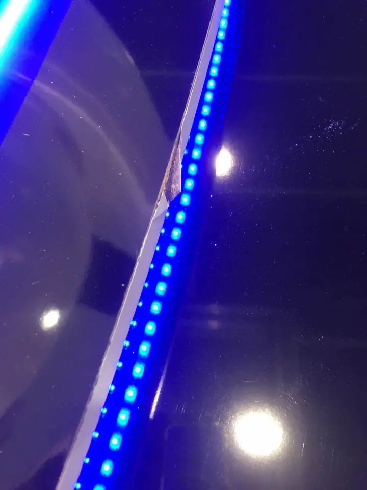 Close detail of blue light strips running along a curved black edge