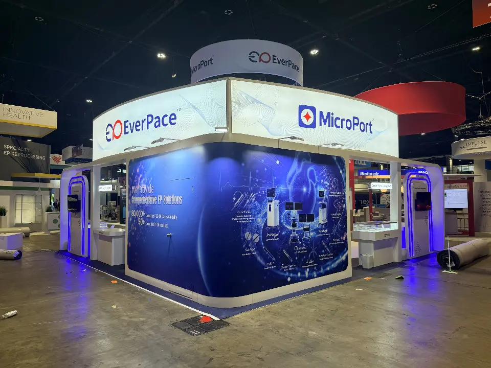 Closer corner view of the lit header, blue graphic wall and arched kiosks