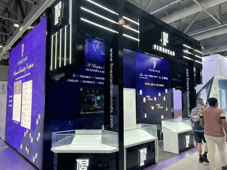 Front of the booth with white glass showcases and lit F monograms