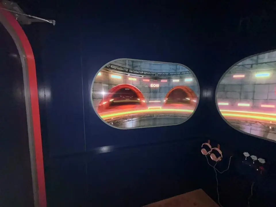 Dark inner room with oval windows and headsets on the wall