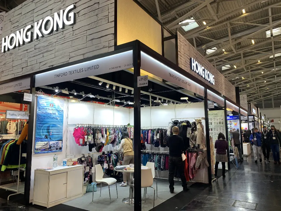 Stand with framed graphics and a counter as visitors browse the pavilion