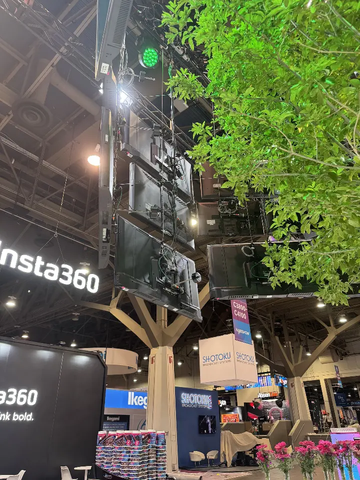 Portrait view of the black Insta360 wall beside a leafy tree