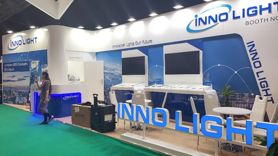 Lit 3D INNO LIGHT letters in front of display tables and visitors