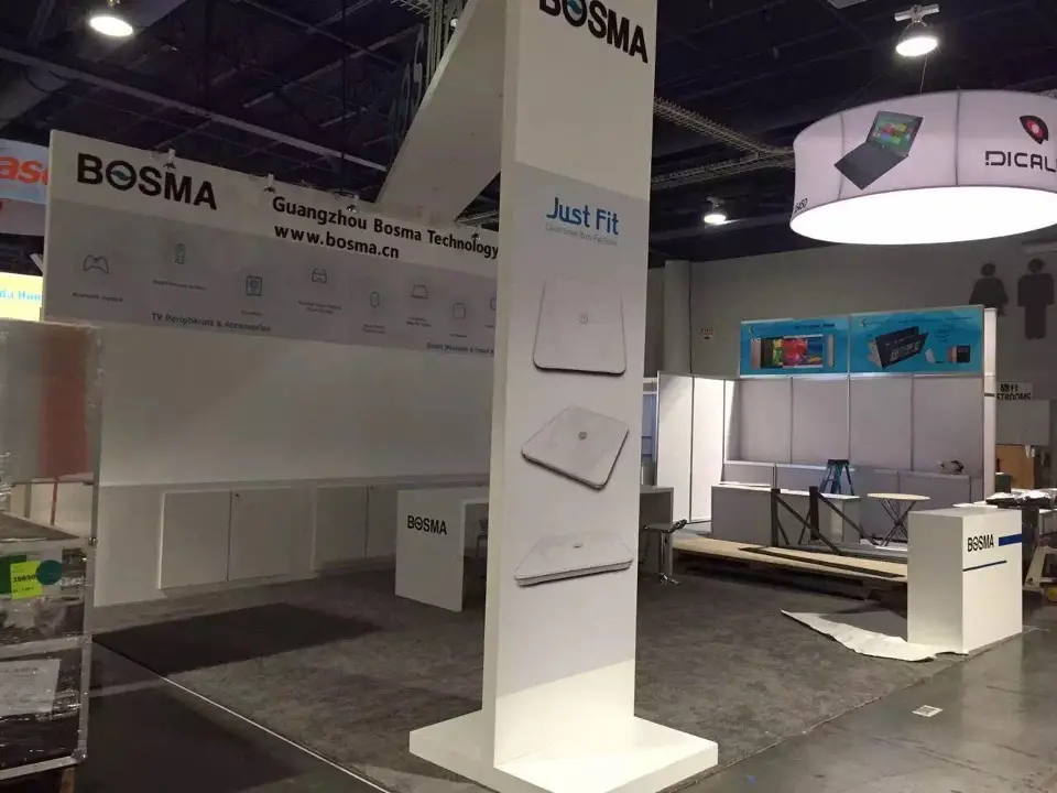 Tall white BOSMA column with product graphics beside the white back wall before opening