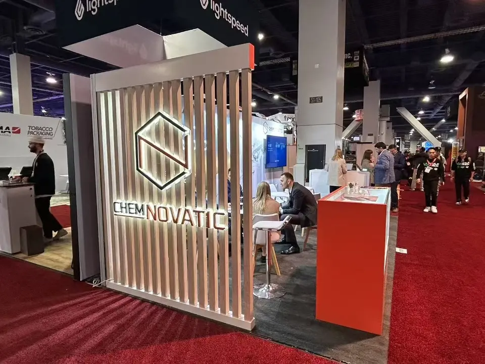 White slatted wall with the CHEMNOVATIC logo beside an orange counter on red carpet