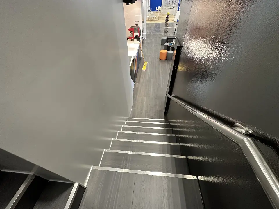 View down the black staircase with white step edges