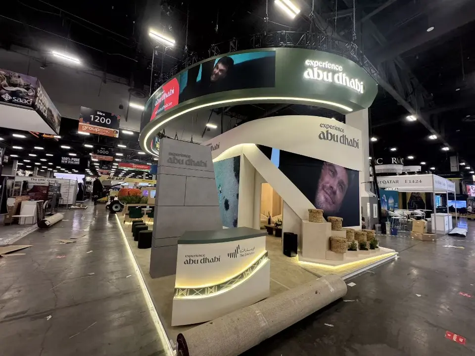 Curved white counter with abu dhabi branding and lit base