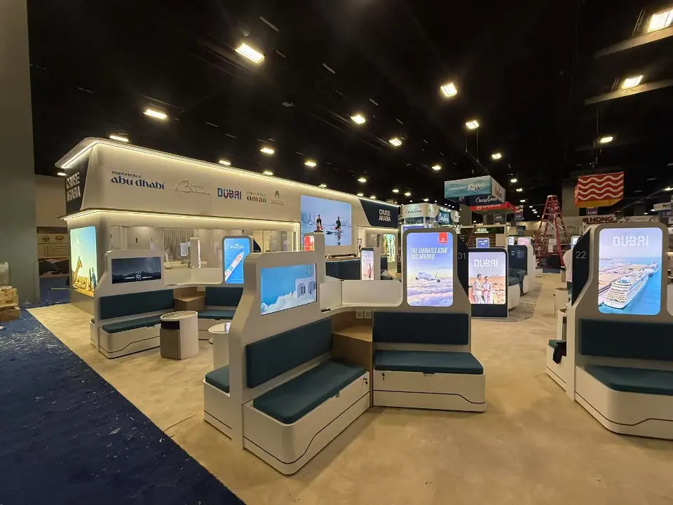 Rows of teal seating pods with backlit graphics under the curved white header