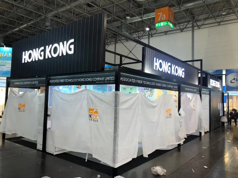 Pavilion corner with lit HONG KONG lettering above a white reception counter