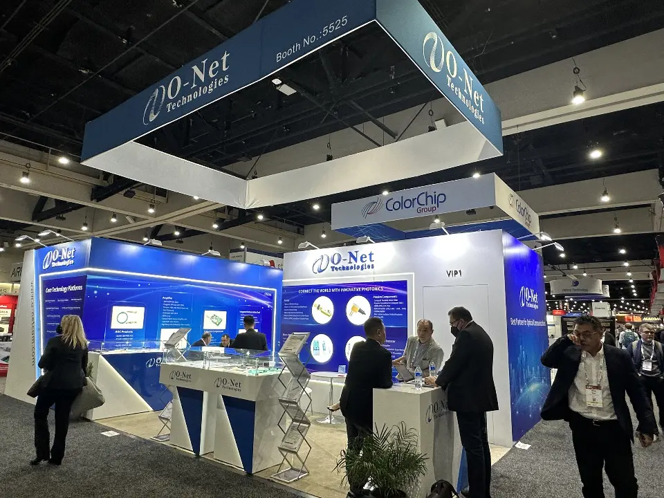 Visitors at white counters with angled bases inside the O-Net booth