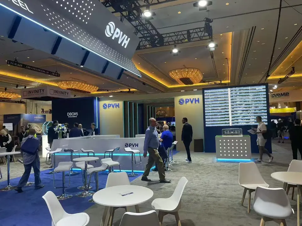 PVH stand at RE+ seen across its lounge of white tables and chairs toward branded display towers