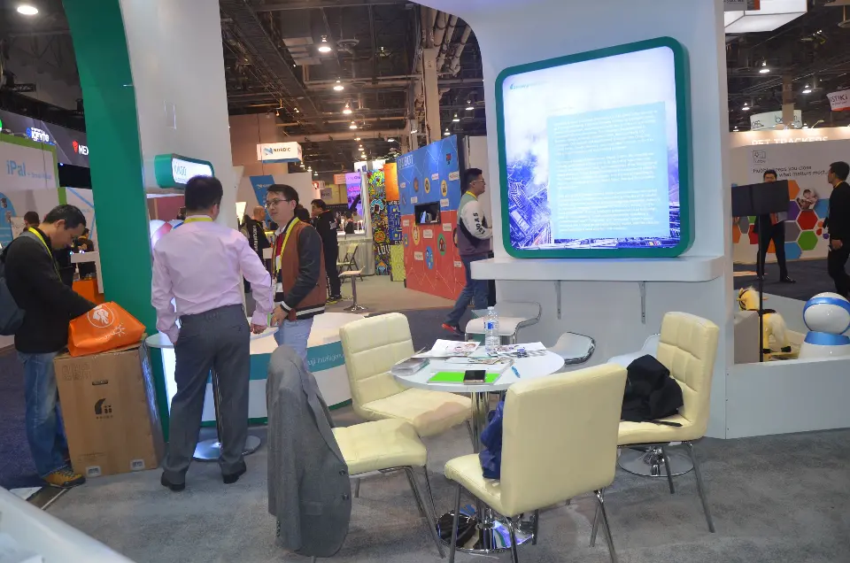 Meeting area with cream chairs beside a backlit robot screen and teal frame