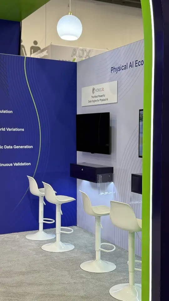 Side demo station under the arch with stools and a screen