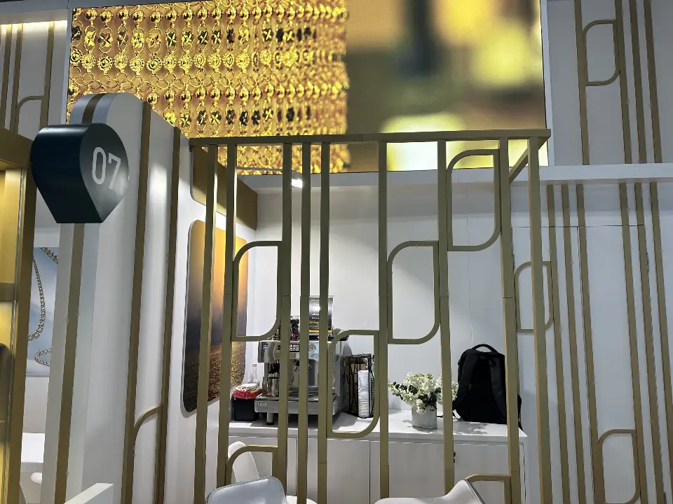 Gold grille panel in front of a lit jewelry graphic, close view