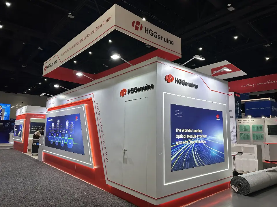 Corner of the HGGenuine booth with red angled panels and a large backlit blue graphic