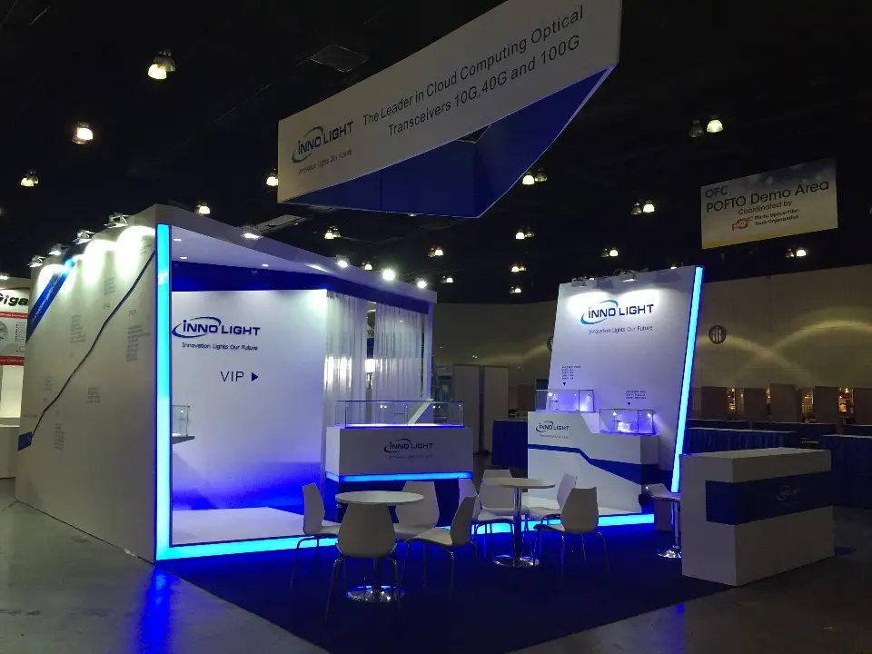 Open booth area with white counters, display cases and blue lit edges