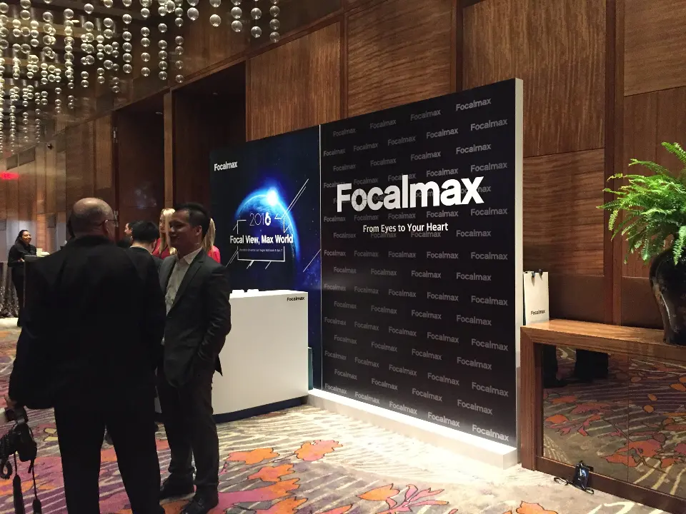 Guests gathered beside a Focalmax backlit display wall in a hotel foyer