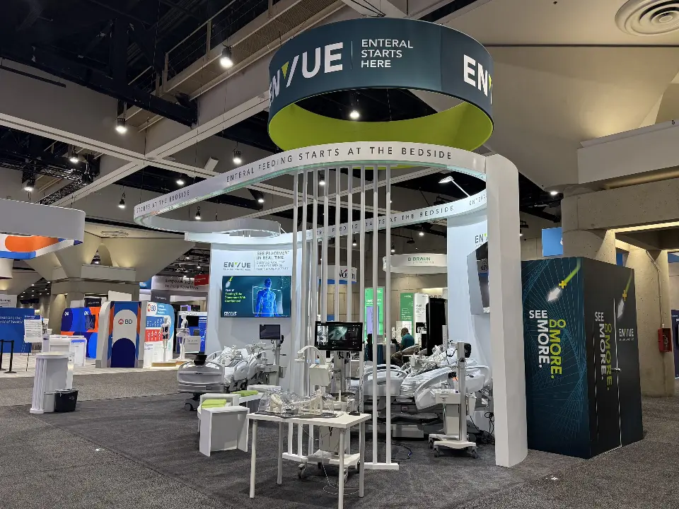Front view under the ENVUE ring sign with slats, demo beds and a central screen