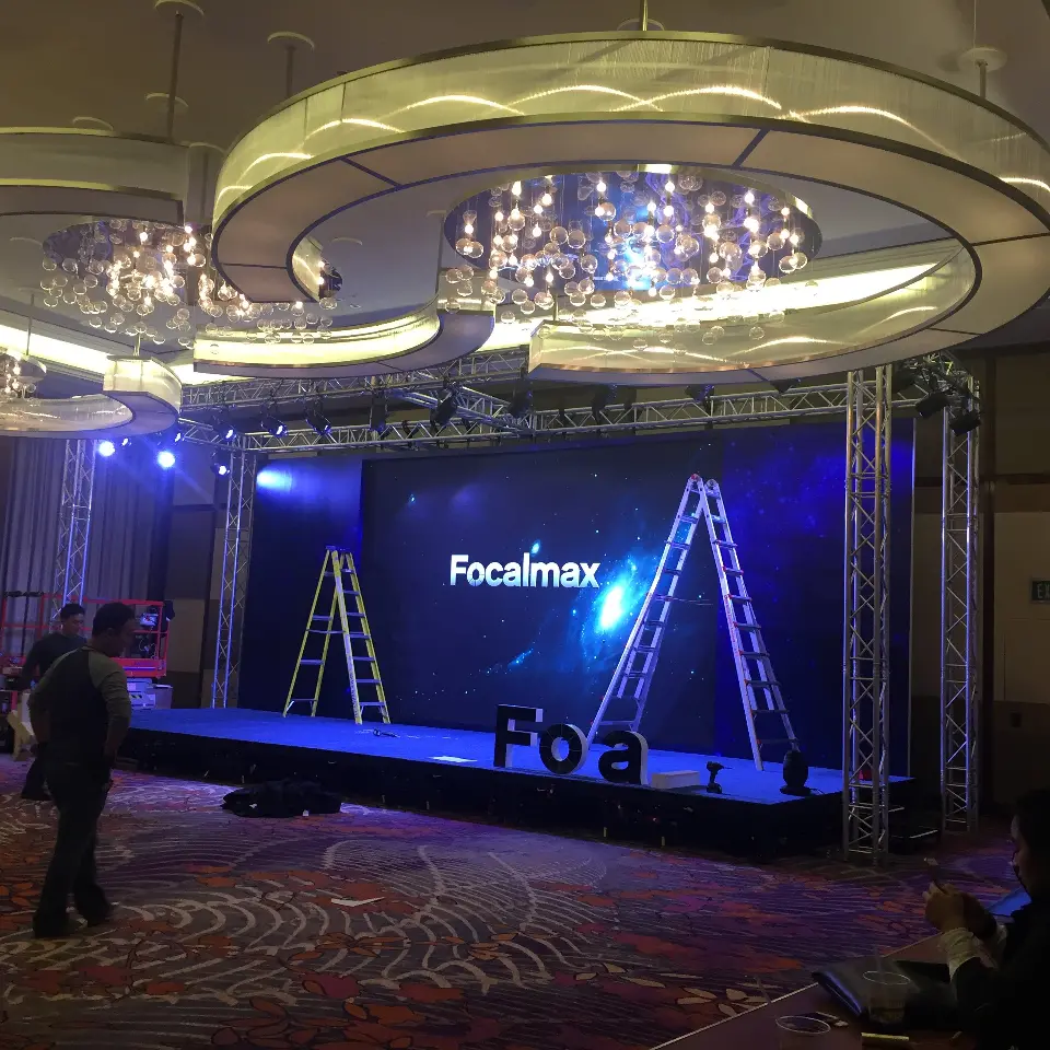 Stage setup with ladders in front of the Focalmax video screen and blue lighting