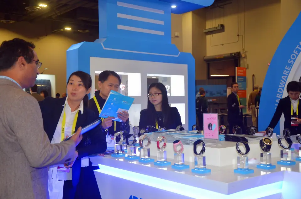 Visitor talking with staff at the counter holding product brochures